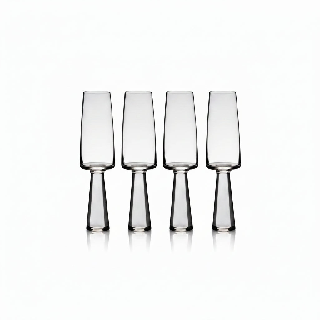 Set of four clear glass flutes on a white background
