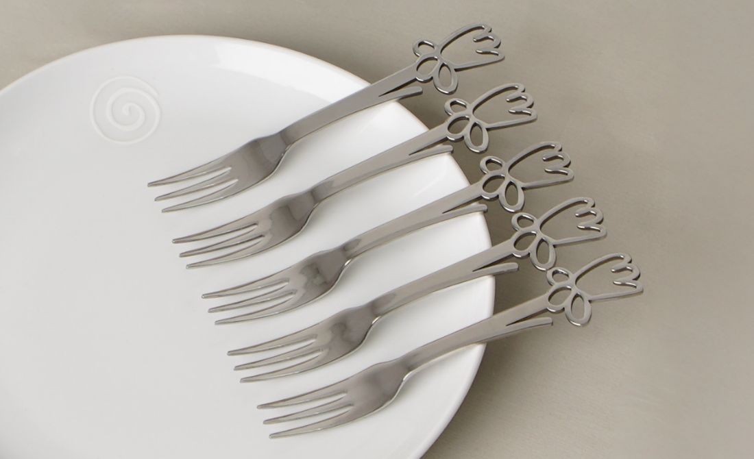Set of polished silverware with daffodil-themed handles, presented in elegant black boxes.
