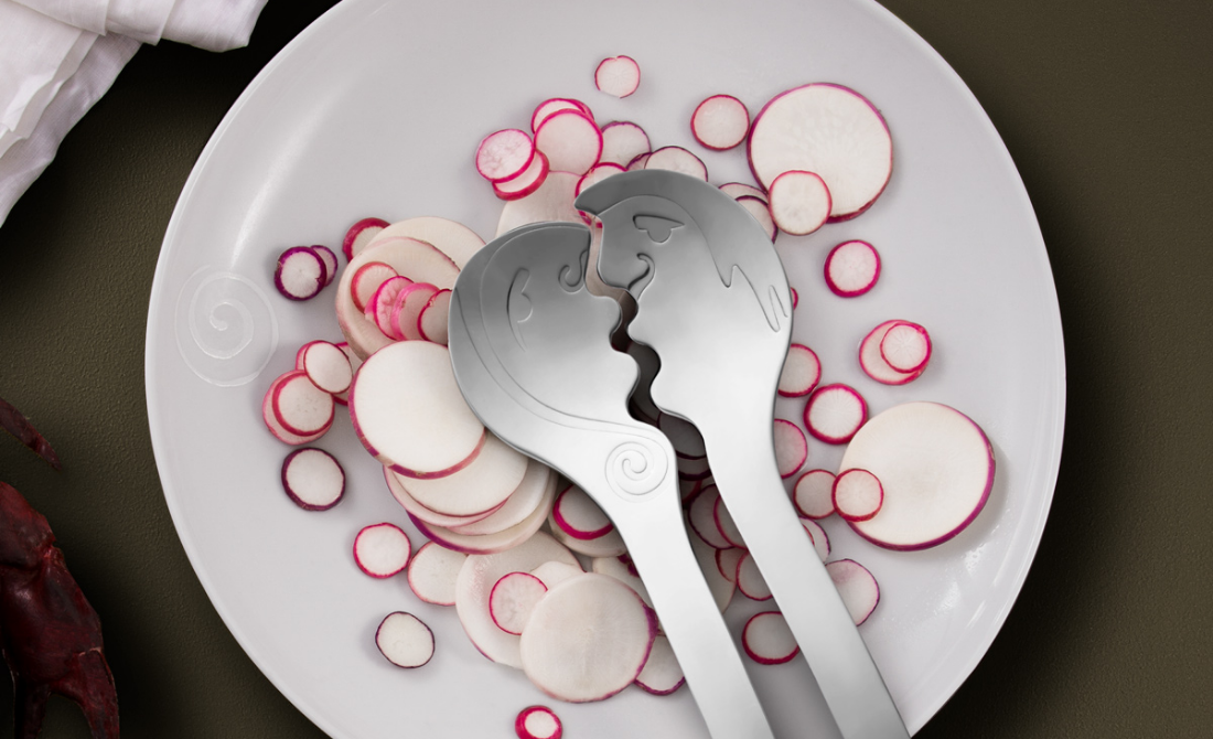 Collection of black bottles and containers with white artistic designs, including hand wash, lotion, hand sanitizer, and a candle, set against a neutral background.