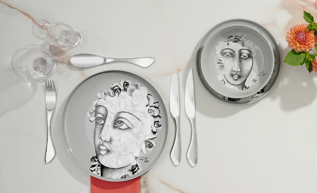 Collection of accessories including pouches and a cloth featuring artistic face designs with floral elements.