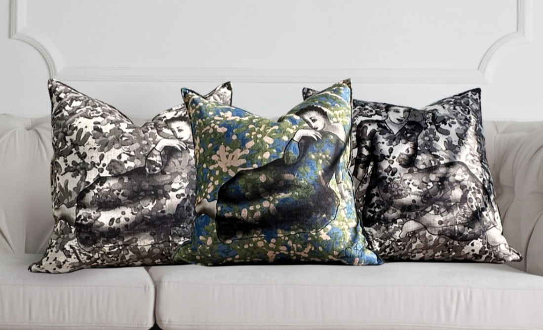 Collection of black bottles and containers with white artistic designs, including hand wash, lotion, hand sanitizer, and a candle, set against a neutral background.