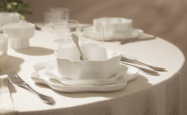 Stylish office accessories a metal pen holder with face design and a clock, with a blue and teal background.